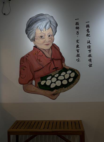 Hand-painted mural of the founder's grandmother holding a tray of yibua