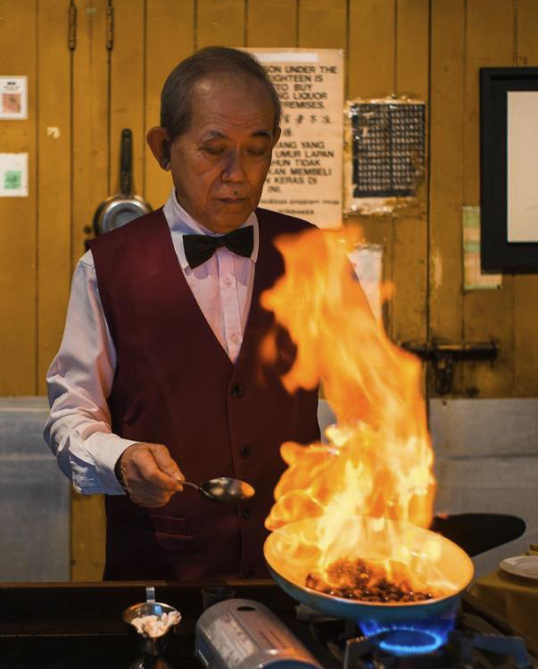 A Shashlik chef flambéing a signature dish tableside