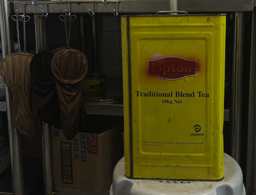 Traditional metal coffee tins and cloth sock filters used at the stall